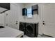 Well-equipped laundry room featuring modern washer and dryer units and storage cabinets at 10313 Orkiney Dr, Las Vegas, NV 89144