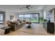 Bright living room with hardwood floors, modern decor, and a large window showcasing the landscaped backyard and pool at 10313 Orkiney Dr, Las Vegas, NV 89144