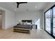 Bright main bedroom features wood-look flooring, a designer bed, and sliding glass doors providing ample natural light at 10313 Orkiney Dr, Las Vegas, NV 89144