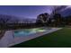 Beautiful in-ground pool surrounded by green artificial turf at dusk at 10313 Orkiney Dr, Las Vegas, NV 89144