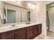 This bathroom has a dual sink vanity with granite counters, dark cabinetry, a shower and plenty of light at 10421 Mount Washington Ave, Las Vegas, NV 89166