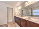 Bathroom with a double sink vanity, large mirror, and tiled floor at 10421 Mount Washington Ave, Las Vegas, NV 89166