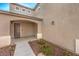 Covered front porch and walkway leading to the door with landscaping of small bushes and red rock at 10421 Mount Washington Ave, Las Vegas, NV 89166