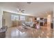 Open-concept living room flows into a modern kitchen with hardwood floors, ceiling fan, and natural light at 10421 Mount Washington Ave, Las Vegas, NV 89166