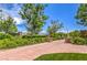 Beautiful view of The Promenade with manicured green hedges, trees, and a red brick path at 10421 Mount Washington Ave, Las Vegas, NV 89166