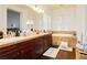 Bathroom featuring double sinks, lots of counter space, a soaking tub, and natural light from the window at 1092 Via Corto St, Henderson, NV 89011