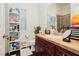 Well-lit bathroom featuring a vanity, decorative mirror, and storage shelves at 1092 Via Corto St, Henderson, NV 89011