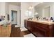 Bathroom with a double sink vanity, wood-look floors, and a door to a walk-in closet at 1092 Via Corto St, Henderson, NV 89011