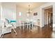 Bright dining area with hardwood floors, a modern chandelier, and a view of the hallway at 1092 Via Corto St, Henderson, NV 89011