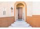 Inviting arched entryway with a wood door and welcome sign at 1092 Via Corto at 1092 Via Corto St, Henderson, NV 89011