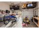 Garage with high ceilings, storage racks, tools, motorcycles and toys at 1092 Via Corto St, Henderson, NV 89011