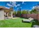 Manicured backyard featuring a covered patio, fire pit, and artificial turf at 11023 Bellatrix Ct, Las Vegas, NV 89135