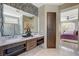 Bathroom showcasing a double vanity, marble counters, and tiled accent wall at 11023 Bellatrix Ct, Las Vegas, NV 89135