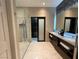 Bathroom with double vanity, frameless glass shower, and a marble tile floor and walls at 11023 Bellatrix Ct, Las Vegas, NV 89135