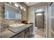 Modern bathroom featuring a stone accent wall, floating vanity, and a glass-enclosed shower at 11023 Bellatrix Ct, Las Vegas, NV 89135