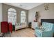 Cozy bedroom featuring two arched windows, a daybed, and a comfortable blue armchair at 11023 Bellatrix Ct, Las Vegas, NV 89135