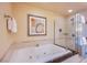 Stylish bathroom featuring a jacuzzi tub, elegant tiling, and a glass-enclosed shower at 135 E Harmon Ave # 2821, Las Vegas, NV 89109