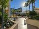 Relaxing courtyard seating area with palm trees and strung lights offers a serene escape at 135 E Harmon Ave # 2821, Las Vegas, NV 89109