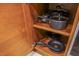 Well-organized kitchen cabinet with pots and pans neatly arranged on wooden shelves at 135 E Harmon Ave # 2821, Las Vegas, NV 89109