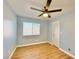 Blue bedroom featuring a ceiling fan, wood floors, and a window with blinds at 1508 Splinter Rock Way, North Las Vegas, NV 89031