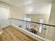 Second floor hallway view with wood floors and railing overlooking the living room at 1508 Splinter Rock Way, North Las Vegas, NV 89031