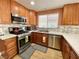 Well-equipped kitchen featuring stainless steel appliances, a mosaic backsplash, and quartz countertops at 1508 Splinter Rock Way, North Las Vegas, NV 89031