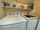 Well-organized laundry room features modern white washer and dryer with storage shelf above at 1508 Splinter Rock Way, North Las Vegas, NV 89031