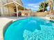 Beautiful backyard pool with a covered patio with a dining set, a grill, and lush landscaping at 1508 Splinter Rock Way, North Las Vegas, NV 89031