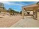 Inviting covered patio overlooking a beautifully landscaped backyard with desert plants and trees at 1616 Langston Hughes St, Henderson, NV 89052