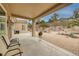 Charming covered patio overlooking a serene gravel yard with desert landscaping and mature trees at 1616 Langston Hughes St, Henderson, NV 89052