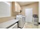 Functional laundry room with front-loading washer/dryer and folding table at 1616 Langston Hughes St, Henderson, NV 89052