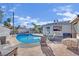 Backyard area with a pool, lounge area with table, chairs, an outdoor tv, and a white brick fence at 1805 Ivanhoe Way, Las Vegas, NV 89102