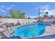 Backyard pool area with blue swimming pool, furniture, white brick fence and trees at 1805 Ivanhoe Way, Las Vegas, NV 89102