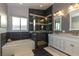 Modern bathroom featuring a sleek bathtub, glass-enclosed shower, and a double vanity with marble countertops at 1905 Sirocco Ct, Las Vegas, NV 89117