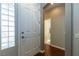 Inviting entryway with a white front door, stylish sidelight window, and wood floors leading to a well-lit hallway at 1905 Sirocco Ct, Las Vegas, NV 89117