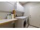 Functional laundry room features a front-loading washer and dryer with overhead cabinets and folding counter space at 1905 Sirocco Ct, Las Vegas, NV 89117