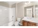 Bathroom with white tub, dark vanity, tile flooring, and neutral paint at 1968 Granemore St, Las Vegas, NV 89135