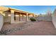 Enclosed backyard with gravel cover, rock border, covered patio and privacy wall at 209 Roxborough St, Henderson, NV 89074