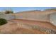 View of the enclosed backyard with a gravel cover and rock border along the block wall at 209 Roxborough St, Henderson, NV 89074