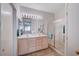 Bright bathroom with double vanity, a large mirror, and enclosed shower for a clean and functional design at 209 Roxborough St, Henderson, NV 89074