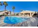 Resort-style community pool with lounge chairs and palm trees under a blue sky at 209 Roxborough St, Henderson, NV 89074