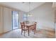 Cozy dining area features a sliding glass door, neutral carpet, and a chandelier for a comfortable living space at 209 Roxborough St, Henderson, NV 89074