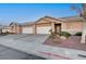 Inviting single-story home with a two-car garage, landscaped yard, and desert rock at 209 Roxborough St, Henderson, NV 89074