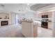 Open-concept kitchen with breakfast bar, white cabinets, and modern appliances at 209 Roxborough St, Henderson, NV 89074