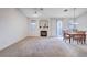 Bright and airy living room with a fireplace, neutral carpet, and dining area at 209 Roxborough St, Henderson, NV 89074