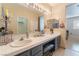 Large vanity in bathroom featuring double sinks, tile countertops and stylish mirror lighting at 2325 Windmill Pkwy # 323, Henderson, NV 89074