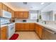 Well-lit kitchen boasts wood cabinets, white countertops, and essential appliances at 2325 Windmill Pkwy # 323, Henderson, NV 89074