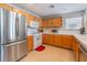 Efficient kitchen with stainless steel refrigerator, white appliances, and wooden cabinets at 2325 Windmill Pkwy # 323, Henderson, NV 89074