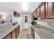 Functional kitchen with wood cabinets, white appliances, and a view of the living area at 2451 N Rainbow Blvd # 1006, Las Vegas, NV 89108