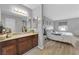 Main bathroom with wood cabinets, granite counters, and adjacent main bedroom at 2451 N Rainbow Blvd # 1006, Las Vegas, NV 89108